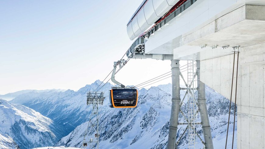 Bild einer Gondel vor einem wunderschönen Bergpanorama. 
