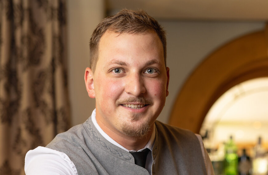 Portrait eines Mitarbeiters des Hotels, der in die Kamera lächelt.