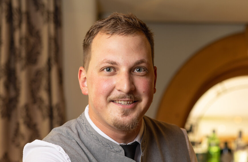 Portrait eines Mitarbeiters des Hotels, der in die Kamera lächelt.