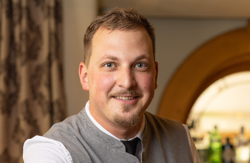 Portrait eines Mitarbeiters des Hotels, der in die Kamera lächelt.