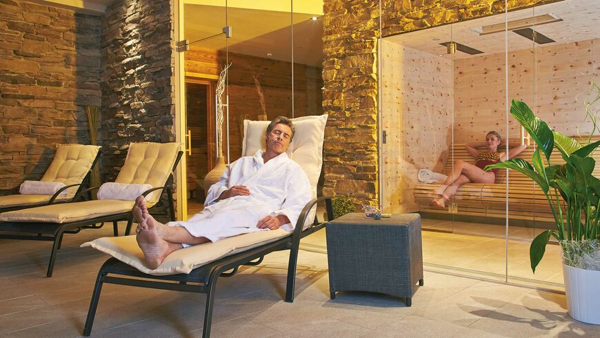 Ein entspanntes Pärchen beim Wellnessen im gemütlich-modernen Sauna- und Ruhebereich