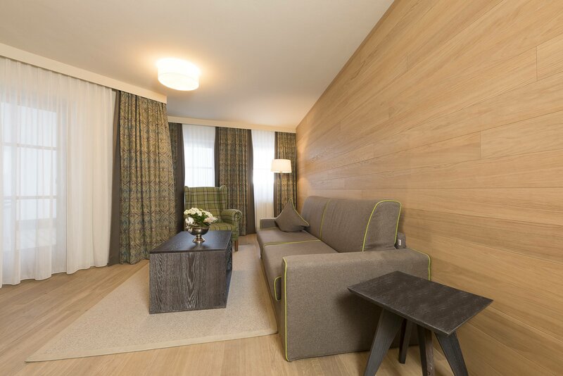 Eine große Couch im Wohnbereich der Suite zum Wohlfühlen im Hotel Alpeiner im Stubaital