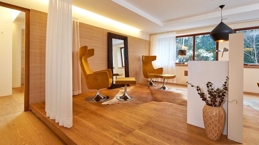 Ein gemütlicher und moderner Ruhebereich mit stilvollen Sesseln und großen Fenstern in einem Hotel in Tirol.