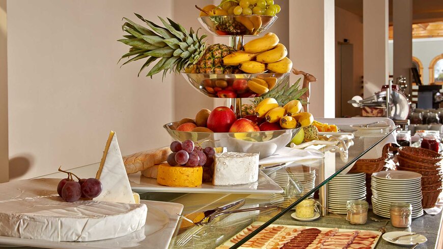 Reichhaltiges Frühstücksbuffet mit frischem Obst, verschiedenen Käsesorten und Wurstwaren in einem Hotel in Tirol.
