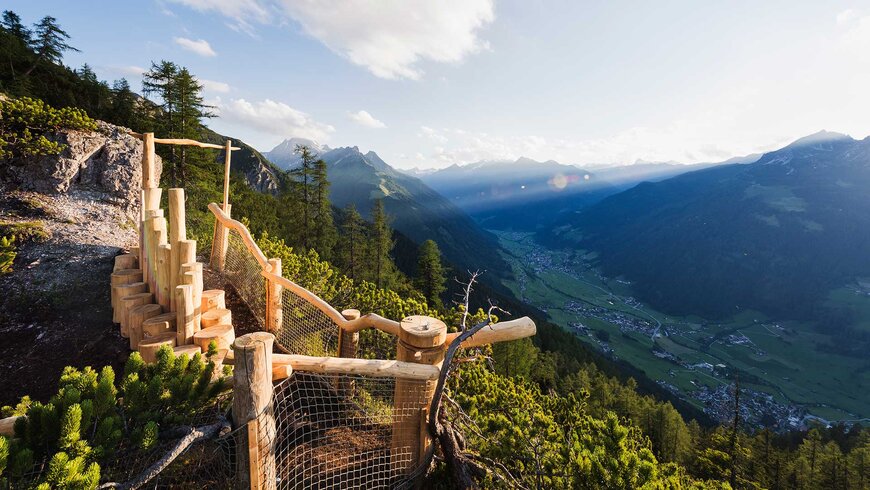 Aussichtsplattform aus Holz mit Blick auf ein malerisches Tal in Tirol.