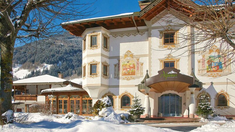 Außenansicht des Alpeiner Hoteleingangs umringt von schneebedeckter Natur des Stubaitals