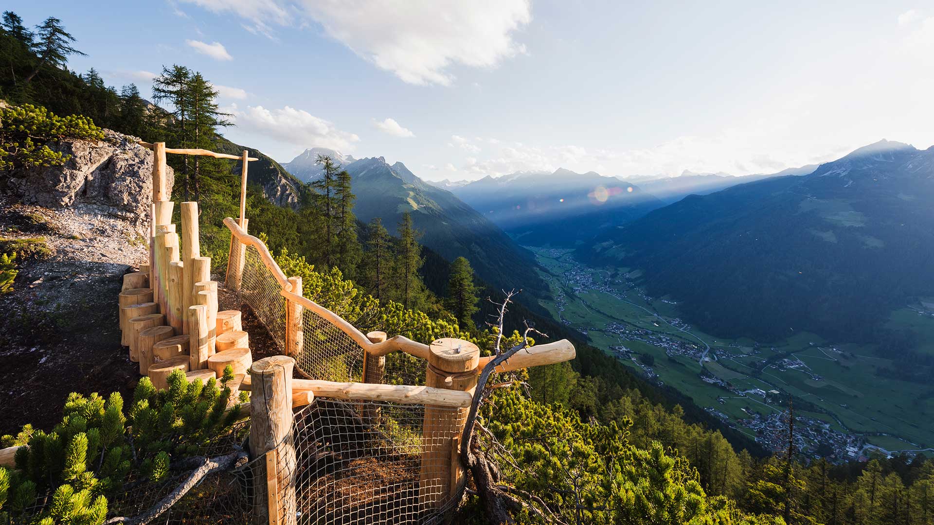 Aussichtsplattform aus Holz mit Blick auf ein malerisches Tal in Tirol.