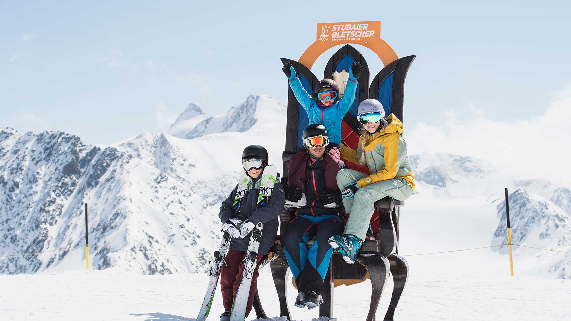 Eine Familie in Ski Kleidung hat Spaß. Im Hintergrund sieht man den Stubaier Gletscher.